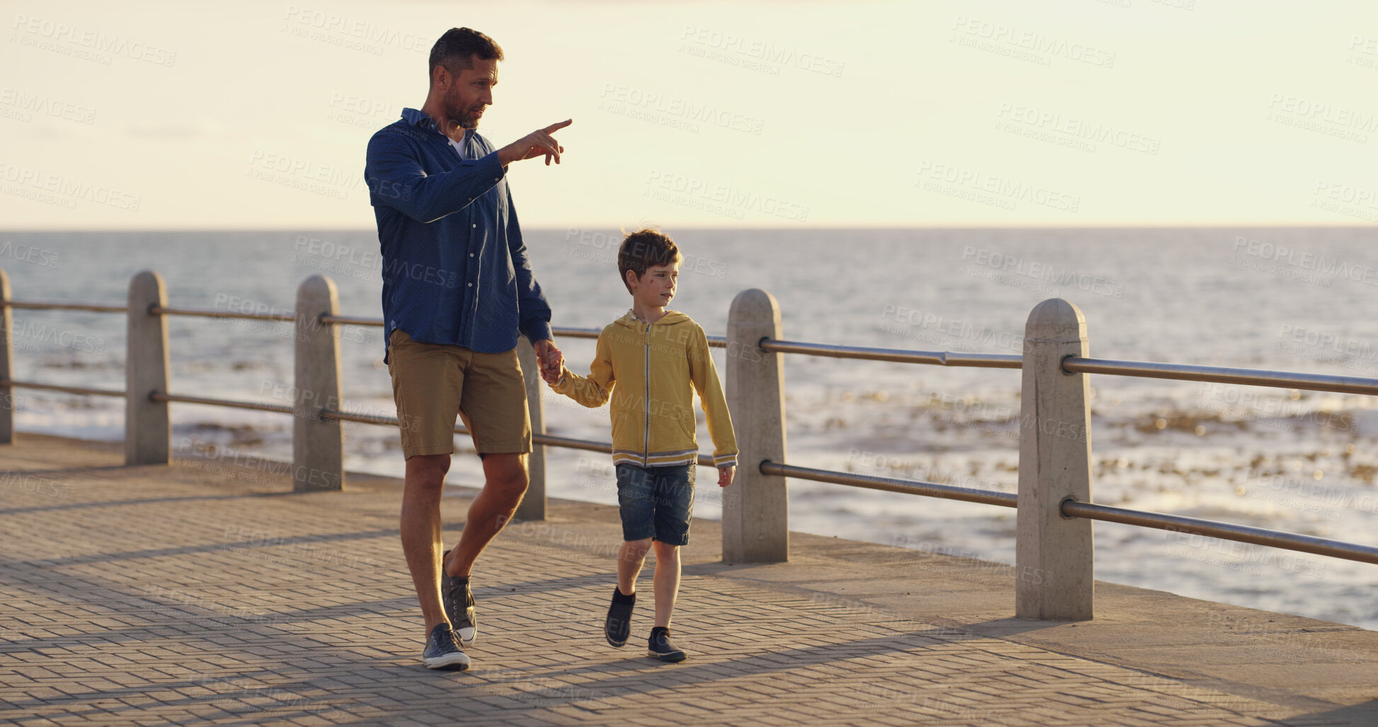 Buy stock photo Dad, son and pointing to sea on walk, sightseeing and outdoor for bonding with father. Boy, child and papa for vacation security in relationship, curious kid and ocean for view of nature on trip