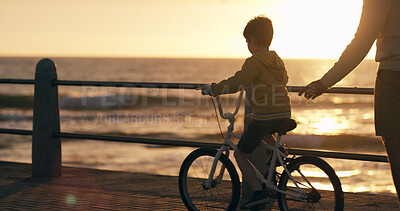 Buy stock photo Parent, boy and bicycle at beach, promenade and with teaching, support and happy on vacation. Person, child and bike with learning, adventure and play in summer with bonding by ocean in New Zealand