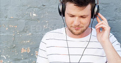 Buy stock photo Headphones, space and man by wall for music, streaming playlist and radio on gray background. Relax, outdoor and male person in city for learning language or listening to podcast with audio sound