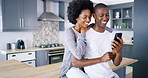 Black couple, mobile and love in kitchen with social media, ecommerce and funny video on internet. Happy man, woman and phone in home for relax, good news and hug on counter with streaming platform