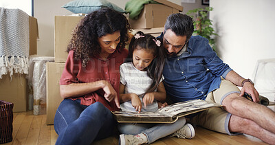 Buy stock photo Memory, parents and kid with photo album in new home for moving in, nostalgia and property investment. Family, people and child on floor with pictures for unpacking, fresh start and house ownership