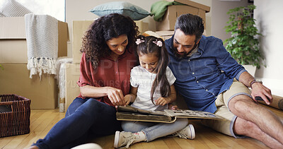Buy stock photo Memory, parents and child with photo album in new home for moving in, nostalgia and property investment. Relax, people and kid on floor with pictures for unpacking, relocation together or real estate