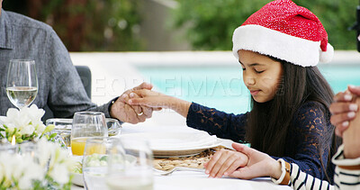 Buy stock photo Christmas lunch, child and family praying in backyard for dinner, gratitude or holiday celebration. Girl, support or people holding hands for supper, feast or food in home for thanks, meal or grace