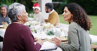 Buy stock photo Christmas, dinner and women with talking by home for bonding, festive celebration or social gathering. Happy family, people and conversation together on patio with food, holiday lunch or relationship
