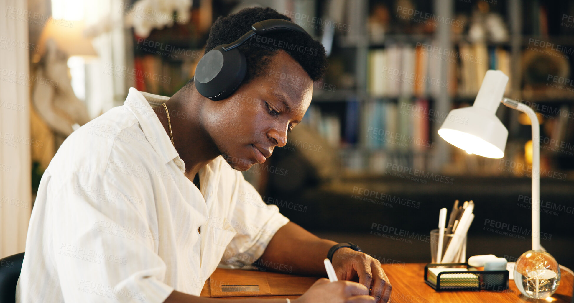 Buy stock photo Headphones, college and writing with black man in home office for listening, course and scholarship. Streaming, university student and education podcast with person and study for report and project