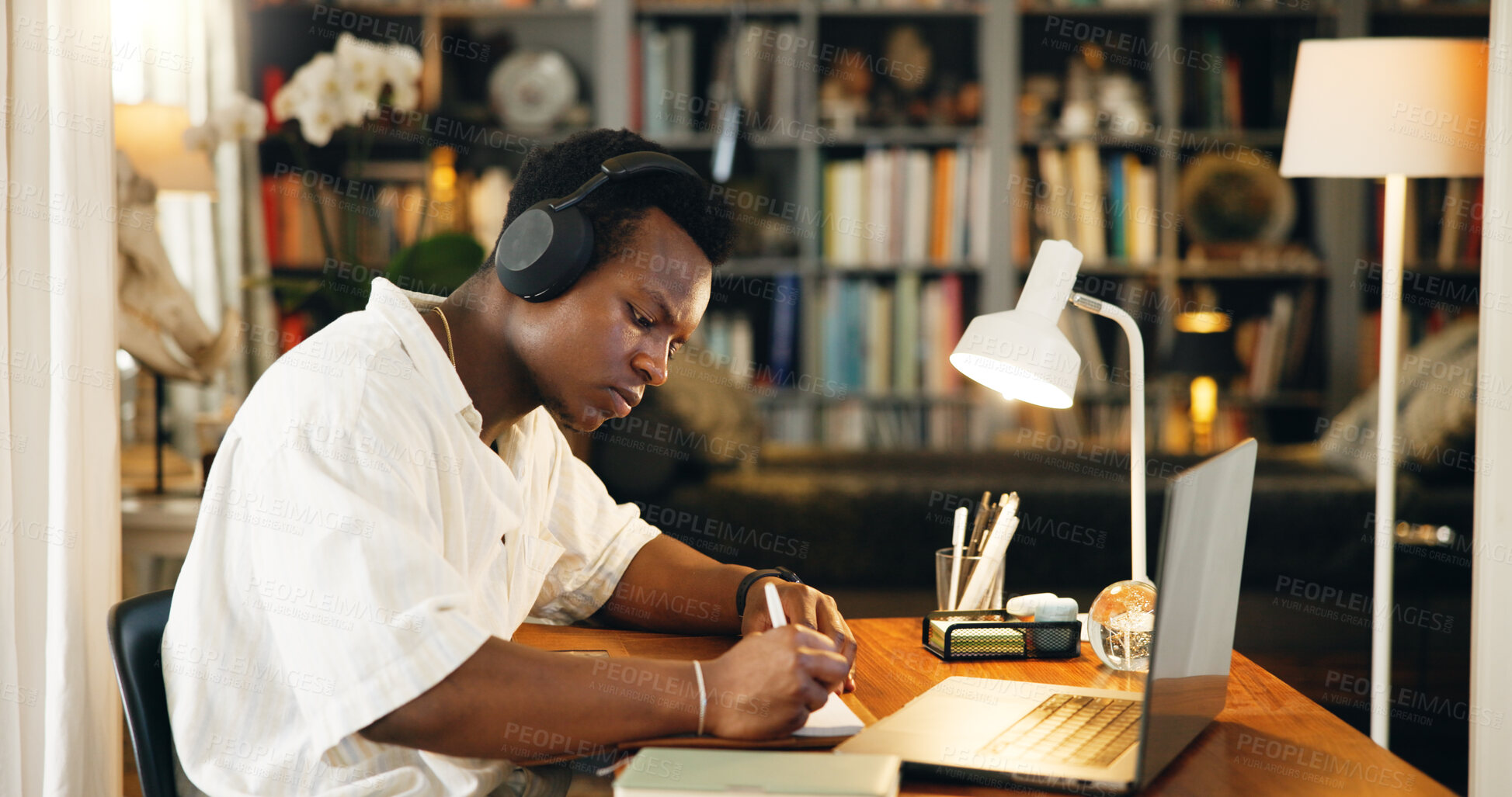 Buy stock photo Laptop, college and headphones with black man writing for research, online course and scholarship. Notebook, university student and elearning webinar with person in home office for report and project