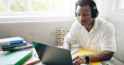 Buy stock photo Black man, laptop and headphones with typing in home with studying, assessment or listening to music with scholarship. Person, student and computer with notes, education or elearning for college exam
