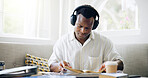 Black man, books and headphones with reading in home with studying, assessment or listening to music with scholarship. Person, student and streaming with notes, education or learning for college exam