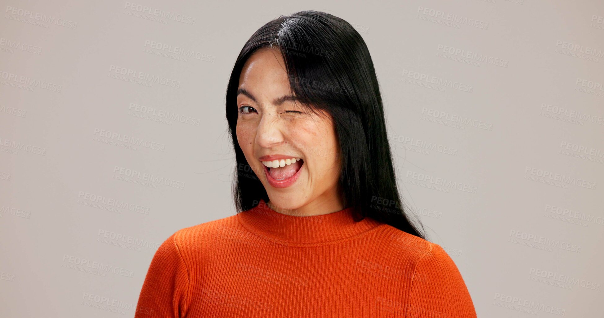 Buy stock photo Asian woman, wink and portrait in studio with smile, playful or flirting with emoji by background. Girl, person and model with funny eye sign, icon and happy with laughing for secret symbol in Taiwan