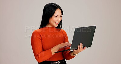 Buy stock photo Chinese woman, laptop and happy in studio with reading, scroll or creative project by background. Girl, person and freelance writer on computer, smile or inspiration with feedback, editing or notes