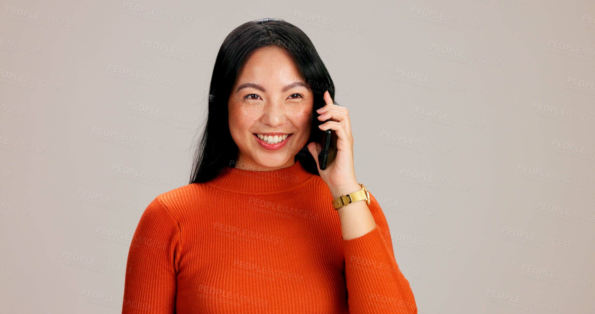 Buy stock photo Woman, phone call and listen by studio background with smile, talk and excited on mobile network. Japanese person, girl and smartphone for chat, happy or contact with conversation, story or gossip