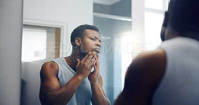 Buy stock photo Black man, face and skincare with mirror for grooming, shave or epilation in bathroom at home. African, male person or dermatology with reflection for skin glow, imperfection or hygiene at house