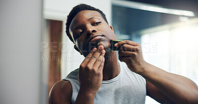 Buy stock photo Black man, gua sha and facial with skincare for anti aging, dermatology or treatment at home. African, male person or face with beauty tool for hygiene, cosmetics or skin routine in bathroom at house