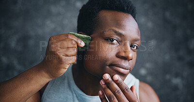Buy stock photo Man, gua sha and face massage in home with tools, process and skincare routine for wellness in morning. African person, jade and stone for circulation, cosmetics and self care for change in bathroom