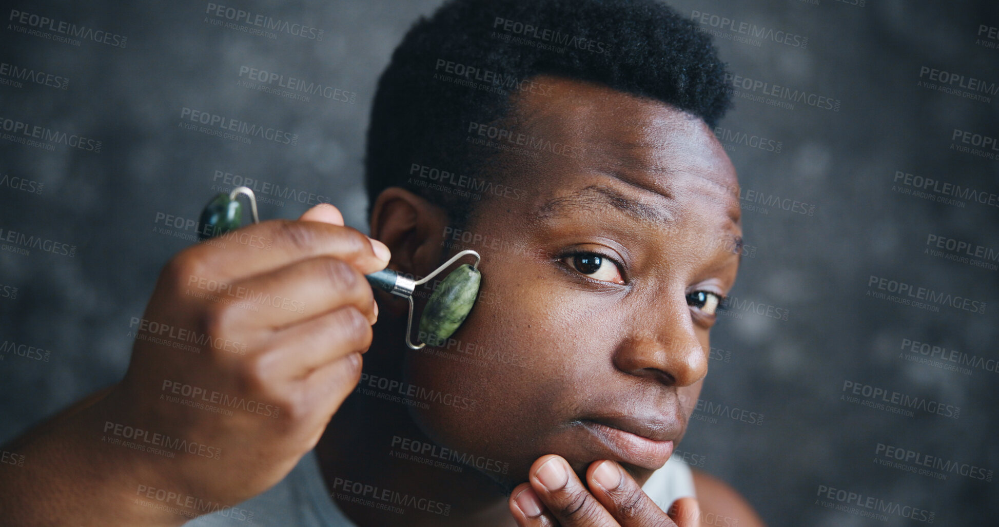 Buy stock photo Man, jade roller and skincare in home for grooming, wellness or stone for massage in morning. African person, tools and facial treatment with process, cosmetics or transformation in bathroom at house