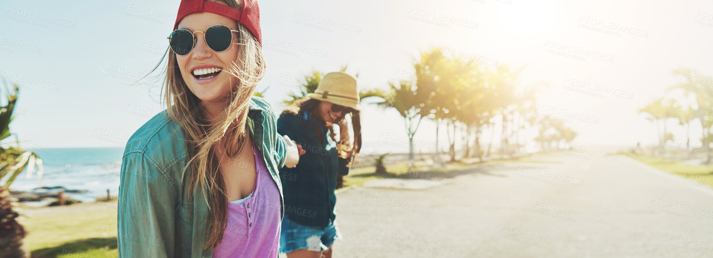 Buy stock photo Friends, beach road and happy on summer holiday while holding hands on adventure together. Women, fun travel and excited by ocean with skater style, outdoor banner and joy on vacation in miami space