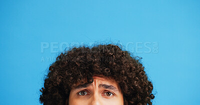 Buy stock photo Raised eyebrow, confused or man in studio portrait with puzzled expression, emoji or eyes. Curly, unsure or afro hair guy with doubt, question or worry on blue background mockup for styling product