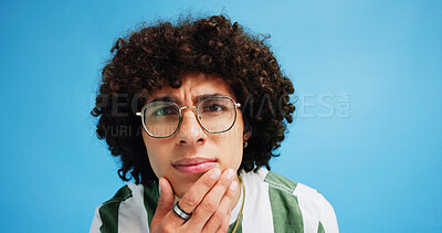 Buy stock photo Thinking, face and man with glasses for brainstorming, problem solving or idea on blue background in studio. Why, questions or model portrait with plan emoji for solution, memory or guess expression