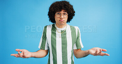 Buy stock photo Shrug, confused and man in studio portrait with puzzled expression, emoji or gesture. Geek, unsure and afro hair guy with glasses and doubt of decision, question or hands up on blue background mockup