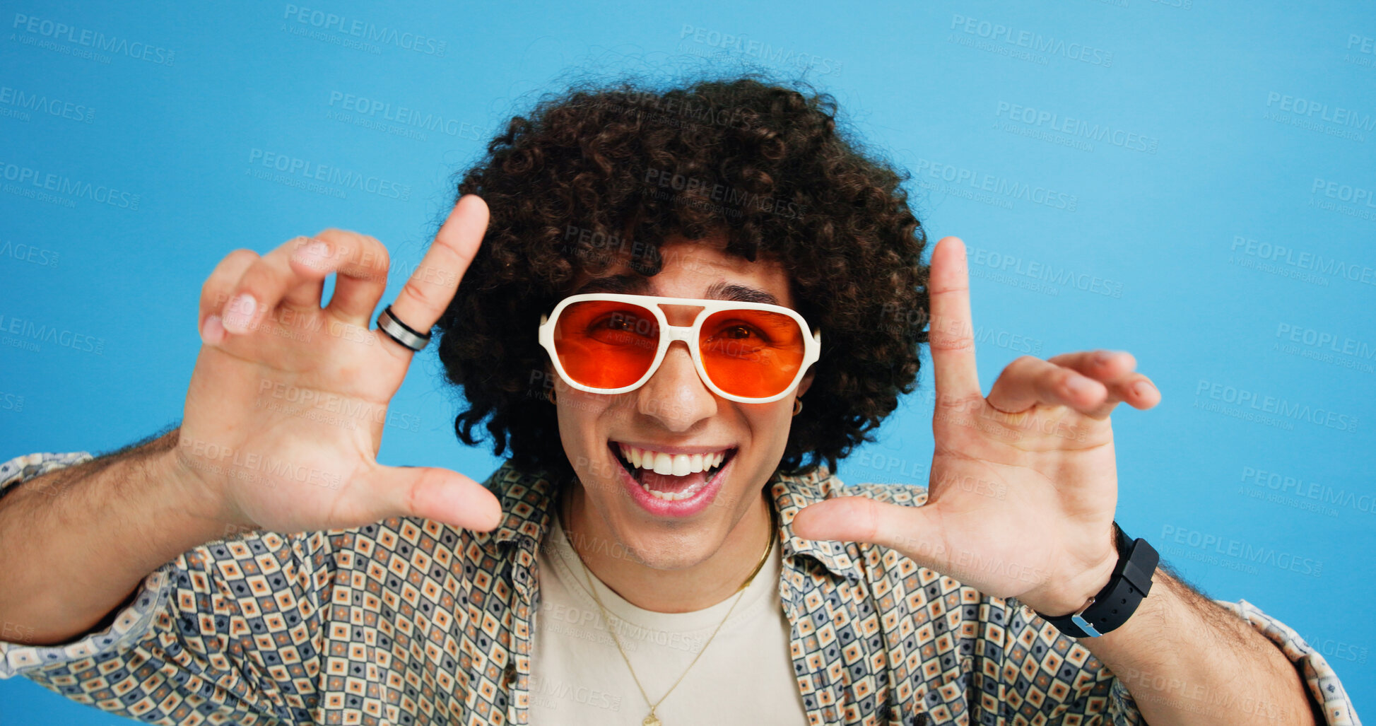 Buy stock photo Happy man, portrait or sunglasses with hairstyle or funky fashion on a blue studio background. Male person, hipster or young model with stylish shades or finger frame for summer party or festive mood