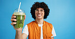 Drink, man and portrait with smoothie in studio, digestive health and fruit juice in recycled plastic. Mockup space, nutritionist or smile with container for green shake, nutrition or blue background