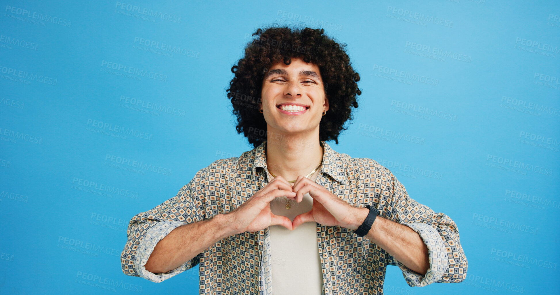 Buy stock photo Studio, happy man and portrait with hands for heart, emoji shape and celebration for valentines day. Smile, male person and romantic gesture by blue background for love, support or kindness by mockup