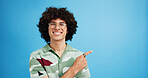 Pointing, portrait and man with opinion, announcement and advertising smile in studio. Blue background, brand promotion and happy person with hand gesture, confidence and information in mockup space