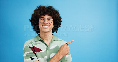 Buy stock photo Pointing, portrait and man with opinion, announcement and advertising smile in studio. Blue background, brand promotion and happy person with hand gesture, confidence and information in mockup space