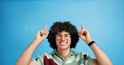 Buy stock photo Pointing up, portrait and man with opinion, announcement and advertising smile in studio. Blue background, brand promotion and person with hand gesture, confidence and information in mockup space