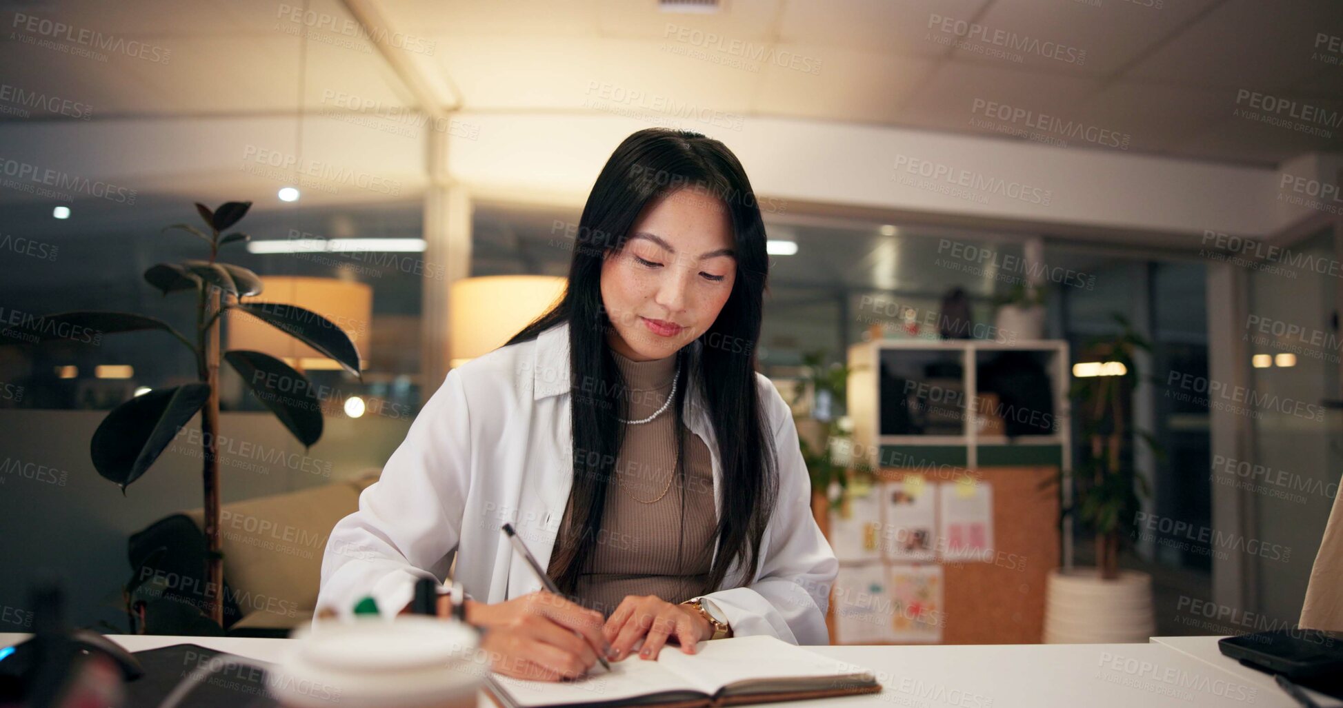 Buy stock photo Asian woman, writing or night with book for project planning, business course or deadline at office desk. Female person, journalist or copywriter taking notes in diary for education, reminder or idea