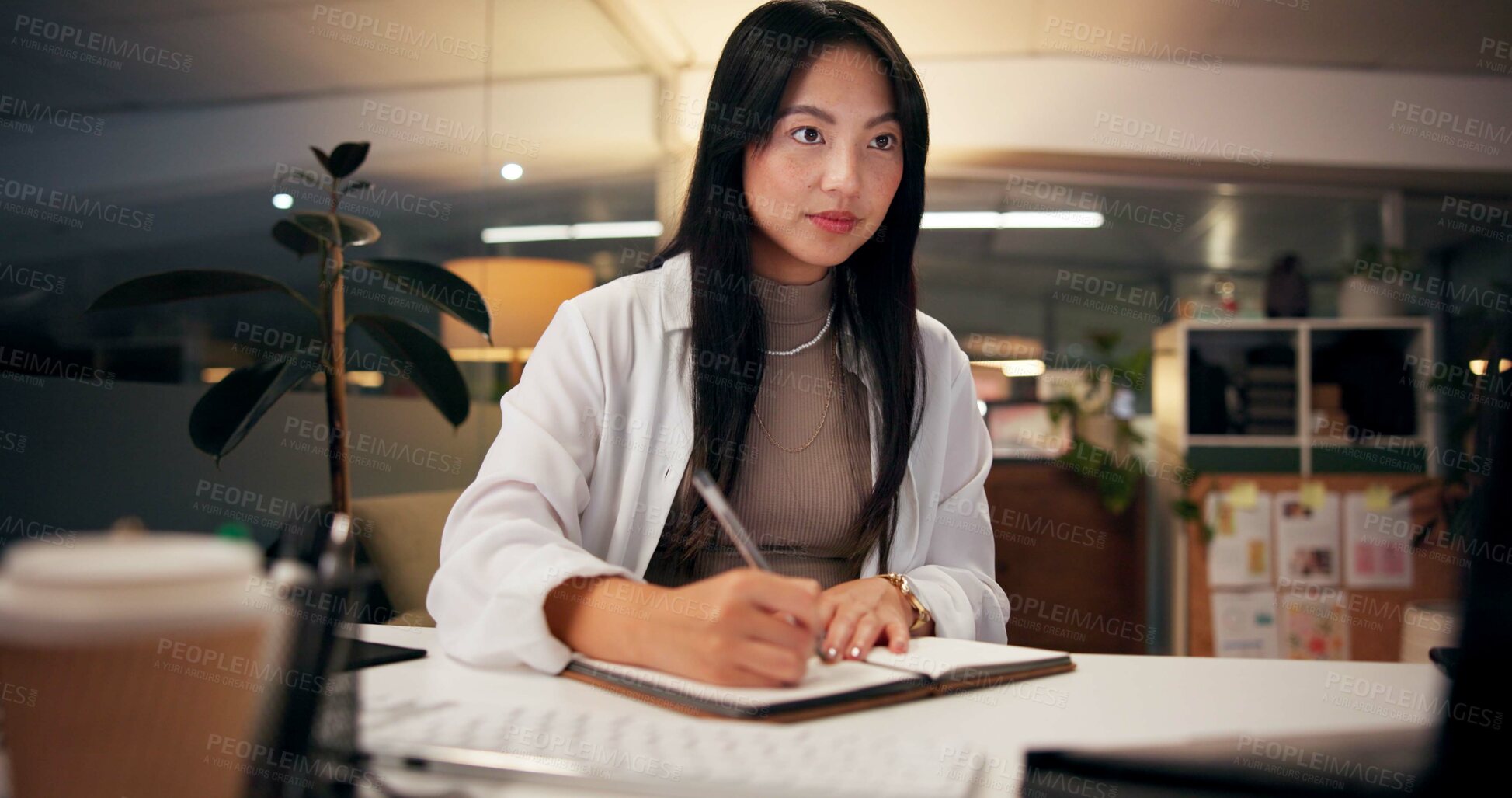 Buy stock photo Asian woman, writing and night with book for online research, tutorial or learning at office desk. Female person, employee or journalist working late with diary for reminder or education at workplace