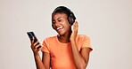 Smartphone, woman and laughing with headphones on studio background for funny audio, radio app and podcast. Music playlist, black person and happy with streaming song, online sound and mockup space