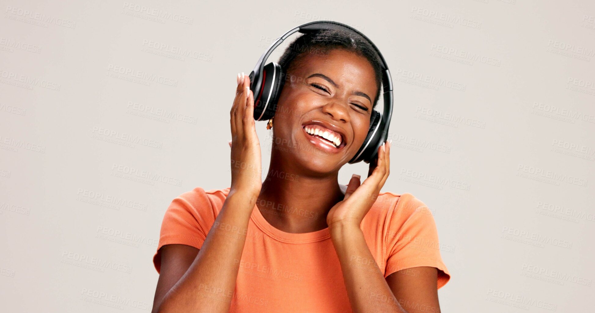 Buy stock photo Music, woman and laughing with headphones on studio background for funny podcast, radio app and enjoyment. Comic playlist, black person and excited with joke, streaming subscription and mockup space