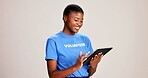 Happy, black woman or volunteer with tablet in studio for charity or community service app on a white background. African, female person or NGO with technology for online donation or global outreach