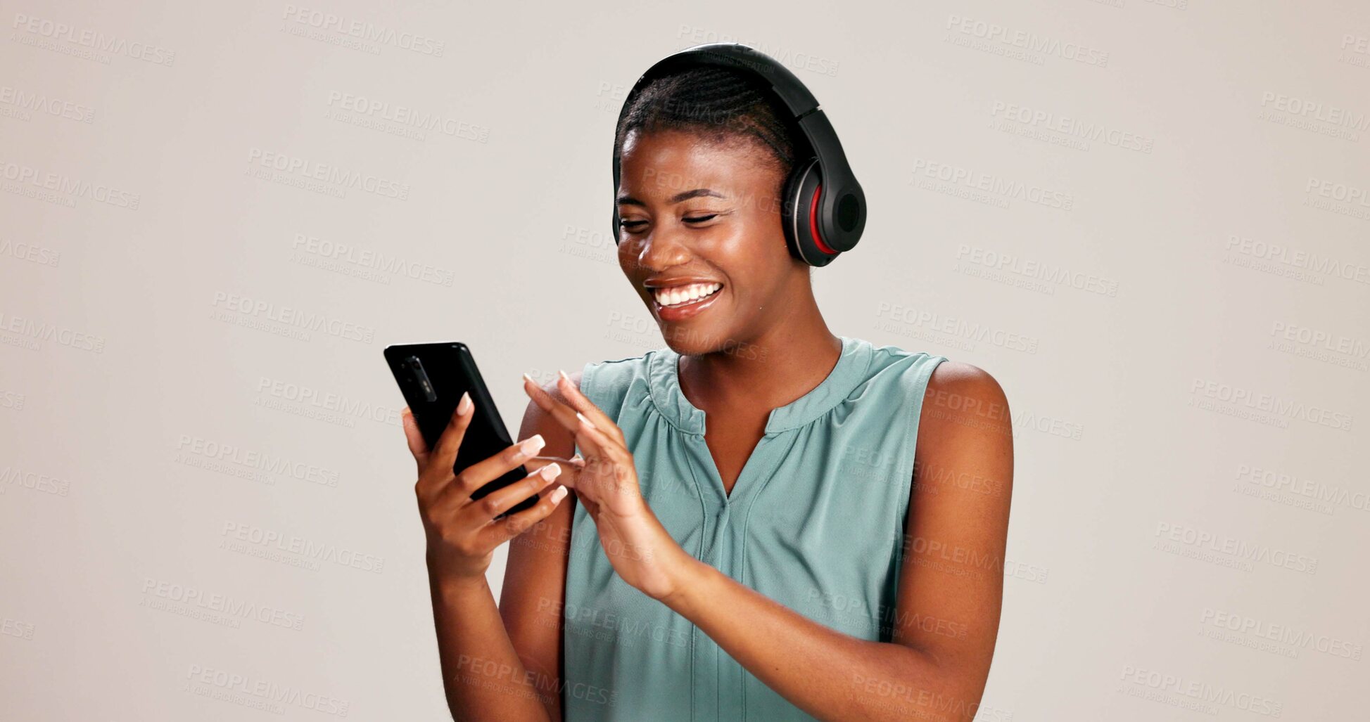 Buy stock photo Smartphone, woman and laughing with headphones on studio background for funny podcast, radio app and audio. Sound playlist, black person and happy with music, mockup space and streaming subscription