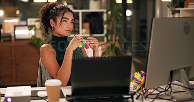 Buy stock photo Business woman, computer and thinking with popit toy, creative agency and ideas for night brainstorming. Girl, brand consultant or multi screen laptop with project, proposal or office fidget stimming