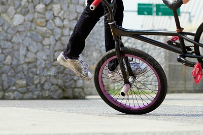 Buy stock photo Legs, wheel and person on bicycle for trick, challenge and action at skatepark in city. Closeup, cycling stunt and urban biker in town with skill for balance, performance risk and freedom of motion