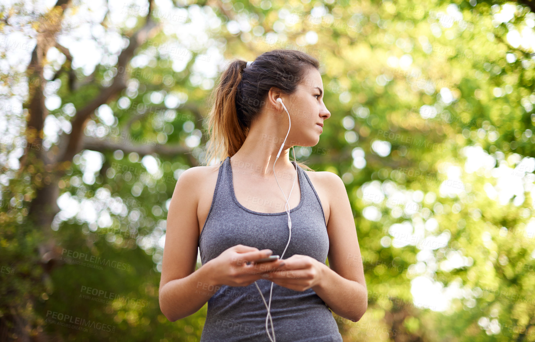 Buy stock photo Runner, fitness and woman with music at park for cardio break, running podcast and relax with audio. Athlete, person and earphones in forest for workout, listening to radio and streaming subscription