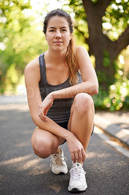 Buy stock photo Woman, portrait and outdoor for fitness with crouch, start and ready for running challenge. Runner, stop and break on road for relax, mental preparation and serious for wellness or self care in Spain