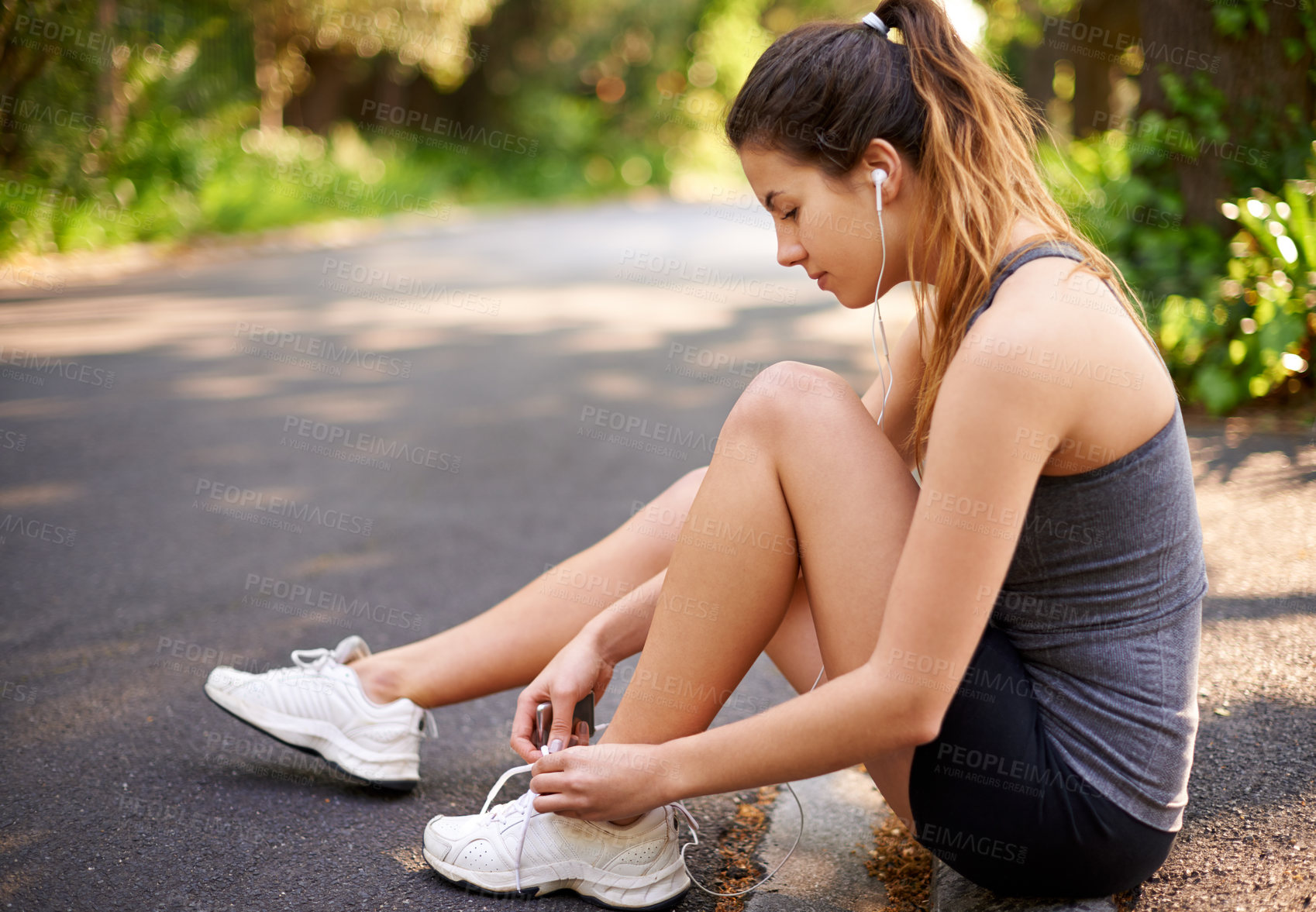 Buy stock photo Woman, fitness and tie shoe on road with music, start or ready for run in park. Runner, earphones or tying sneakers outdoor for wellness, sports or streaming service with training commitment in Italy