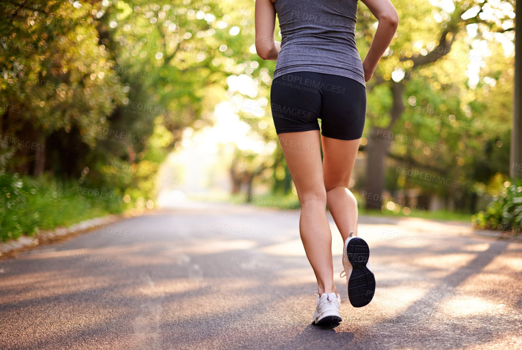 Buy stock photo Running, legs and fitness for runner, street and training for competition with energy, exercise or outdoor. Healthy, athlete and back of person on jog, nature and practice for race on road or workout