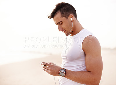 Buy stock photo Earphones, health and man by beach for fitness listening to music, podcast or radio for run. Outdoor, sports and male athlete with audio tech for cardio workout, exercise or training playlist.