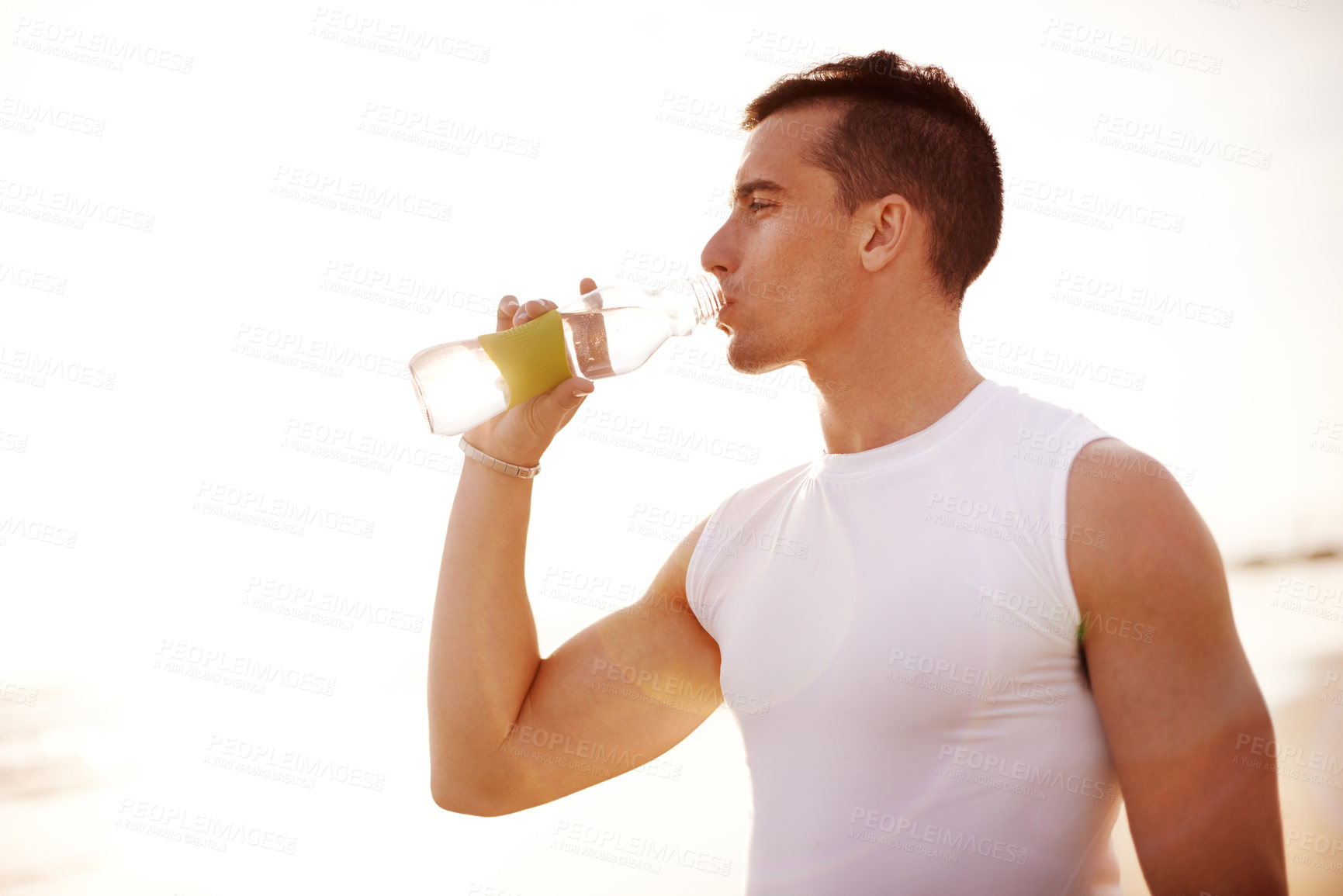 Buy stock photo Fitness, man and drinking water at beach for health, body wellness and relax on sports break at sunset. Outdoor, thirsty runner and bottle for hydration, electrolytes and liquid nutrition for detox