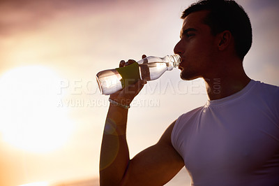 Buy stock photo Fitness, man and drinking water at beach at sunset for health, body wellness and relax on sports break. Outdoor, thirsty runner and bottle for hydration, electrolytes and liquid nutrition for diet