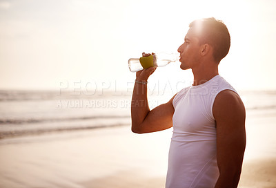 Buy stock photo Fitness, relax and man on beach with drink for hydration, outdoor workout and thinking with waves at sunrise. Water, bottle and runner at ocean with rest, mockup and calm morning exercise in nature