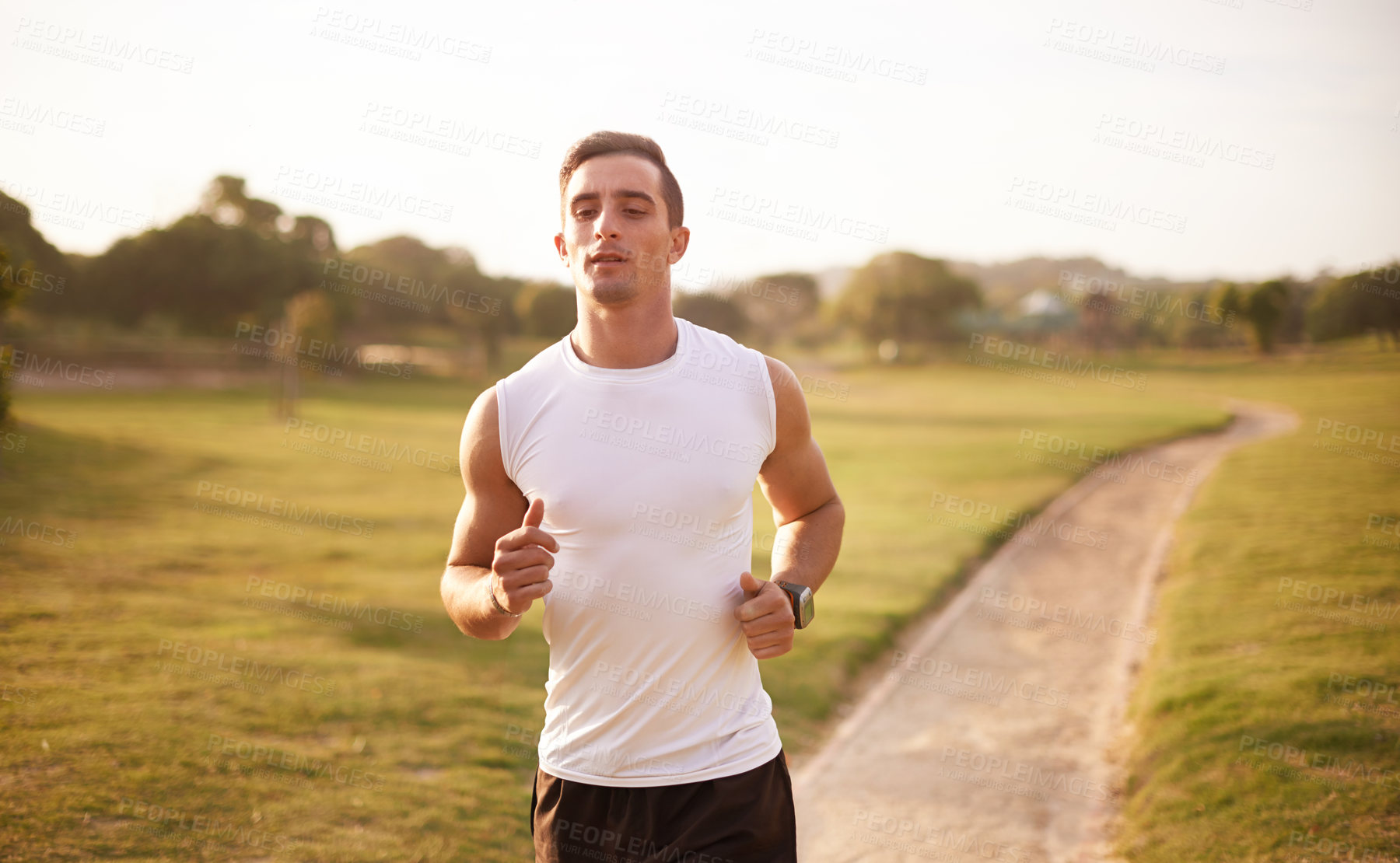 Buy stock photo Nature, running and man with fitness on trail for workout, marathon training or endurance challenge. Sports, wellness and athlete person in park for morning cardio, performance or race in Cardiff