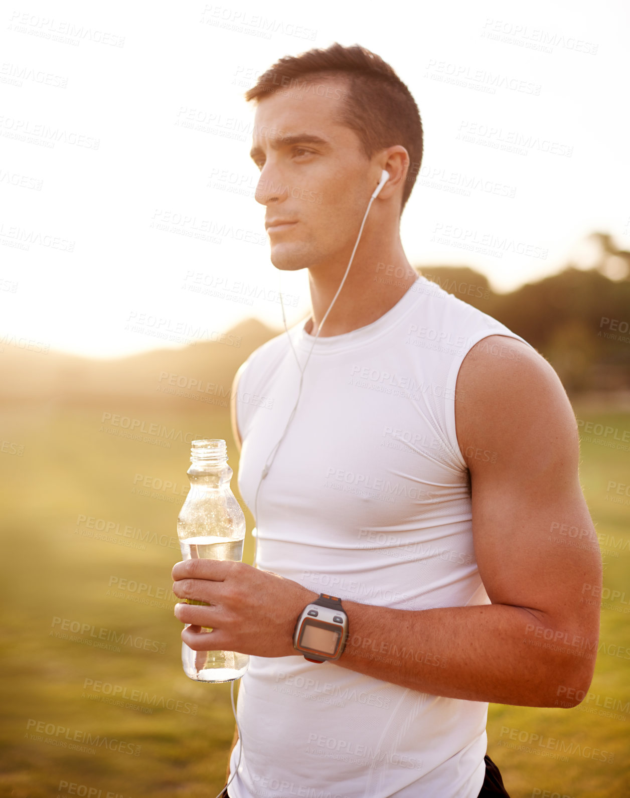 Buy stock photo Fitness, water and man with music at park for streaming workout audio, running break and hydration. Athlete, person and earphones for listening to radio, app marathon training or jog for healthy body