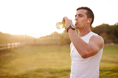 Buy stock photo Fitness music, man and drinking water outdoor for health, body wellness and relax on sports break. Headphones, thirsty runner and bottle for hydration, electrolytes and liquid nutrition at sunset