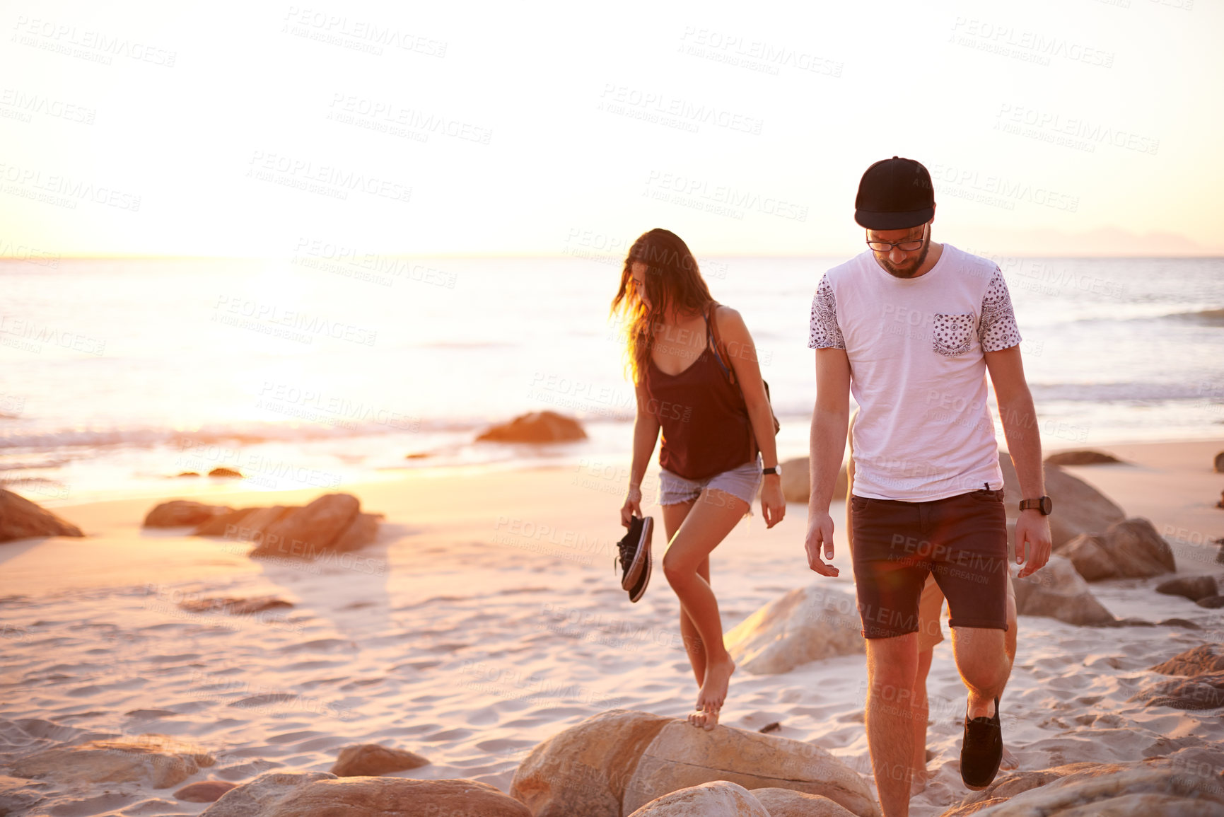 Buy stock photo Couple of friends, sunset and walk at ocean for journey, summer holiday and explore nature. People, travel and vacation on Australia beach for adventure, outdoor trip and peaceful weekend with space
