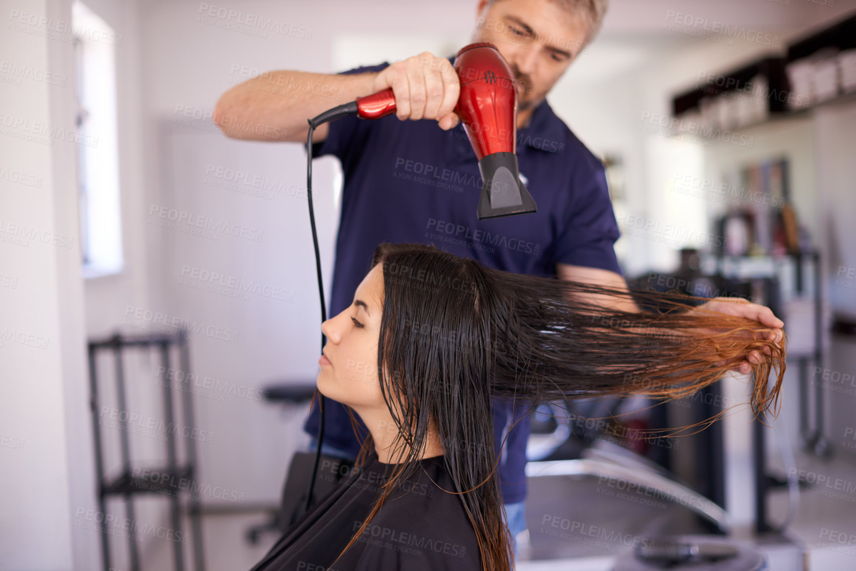 Buy stock photo Woman, beauty salon and blow dry by stylist, cosmetic service and electric tool for treatment. Female person, client and expert for hairstyle appointment, hair care and grooming for transformation